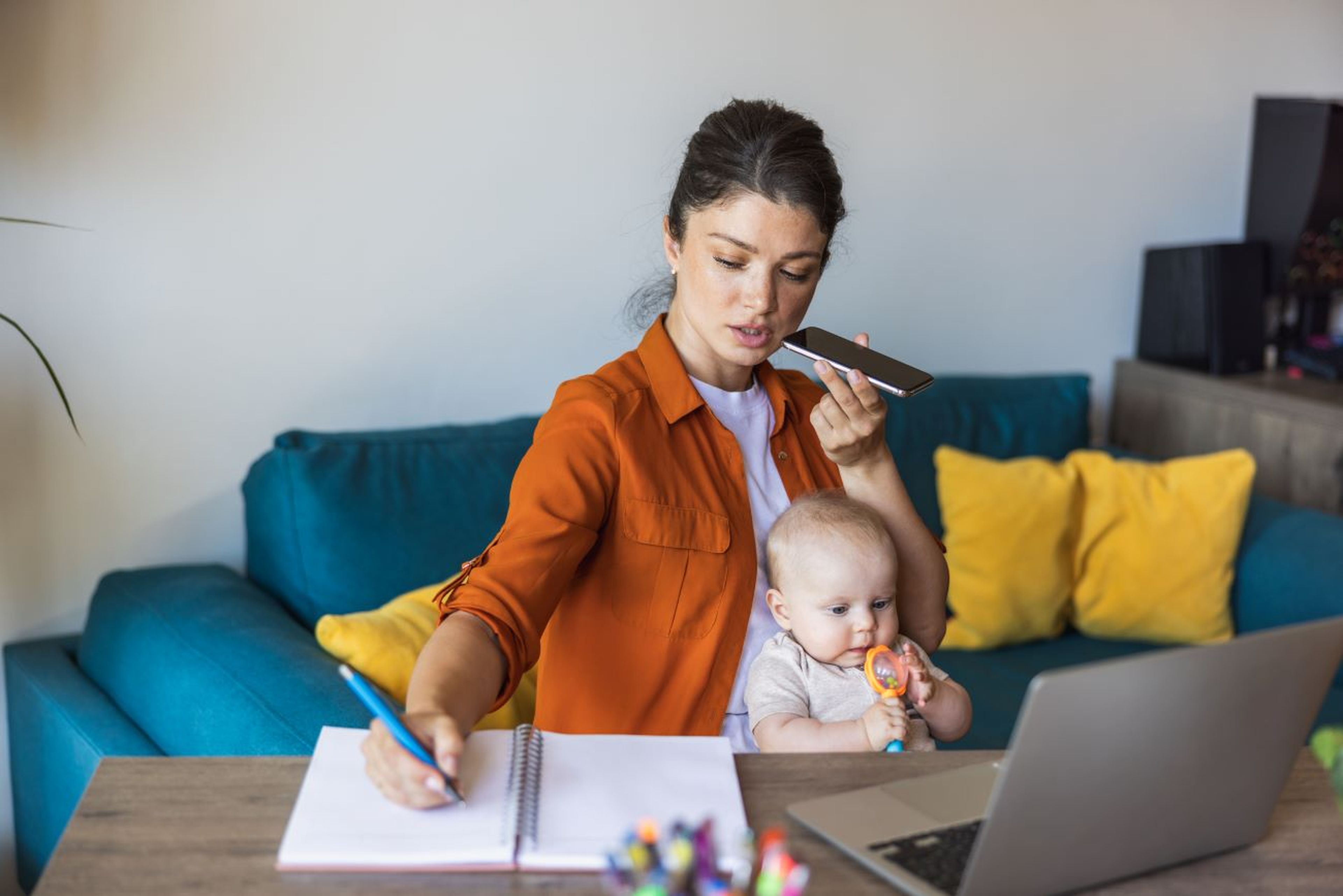 Madre trabaja y cuida bebé