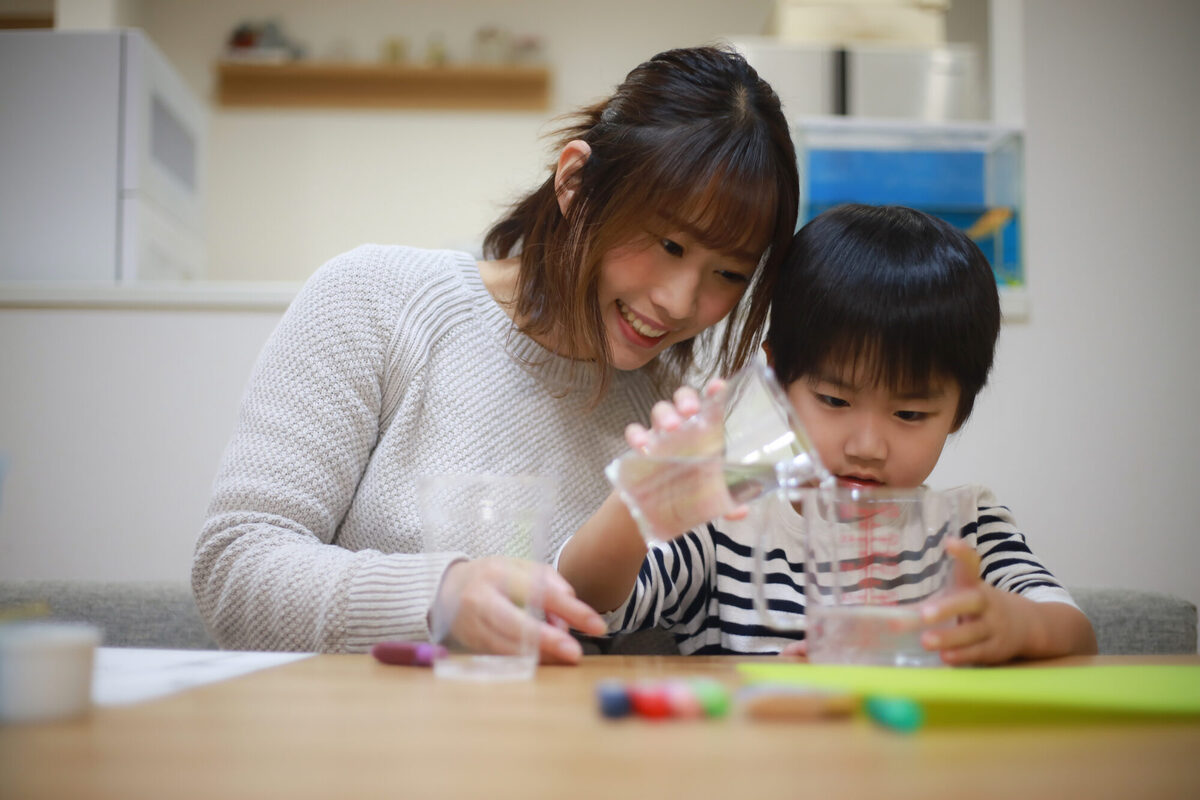 水を計量する子どもとお母さんのイメージ写真