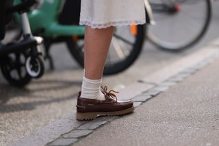 a model on the sidewalk wearing the boat shoe trend