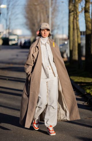 COPENHAGEN, DENMARK - FEBRUARY 02: Jacqueline Zelwis wears Ralph Lauren cap, brown trench coat, white turtleneck, jacket, pants, Copenhagen Studios sneaker outside Holzweiler during the Copenhagen Fashion Week Autumn/Winter 2023 on February 02, 2023 in Copenhagen, Denmark. (Photo by Christian Vierig/Getty Images)