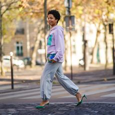 stylish woman wearing trendy gray sweatpants and green heels