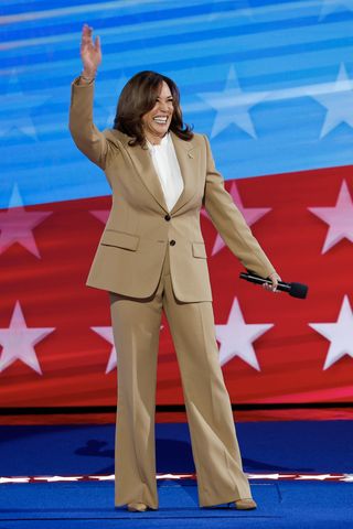 kamala harris waving in a tan suit