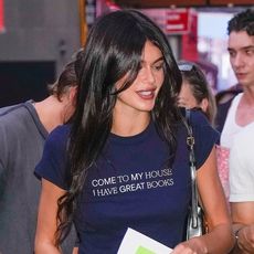 Kaia Gerber wearing a "Come to my house, I have great books" navy tee with navy leggings and black pumps in New York City July 2024