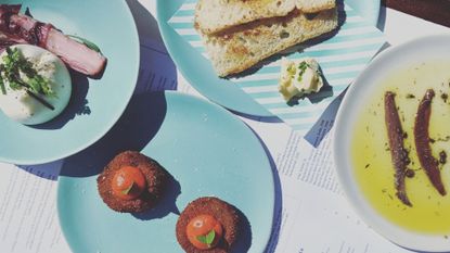 Table full of food on blue plates to showcase Lydia Swinscoe dining alone