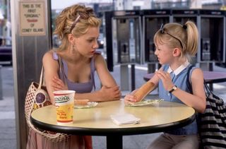 Brittany Murphy sits at a table with a young Dakota Fanning in 'Uptown Girls'