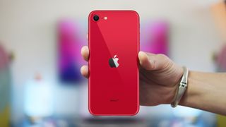 Red iPhone SE in someone's hand