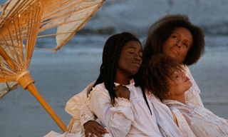 family sitting on the beach in daughters of the dust