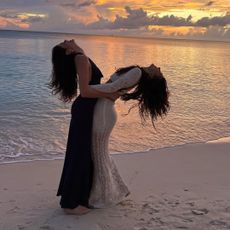 kaia gerber and camila morrone on a beach in matching vacation dresses