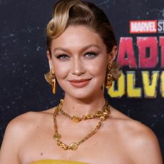 Gigi Hadid on the Deadpool x Wolverine red carpet wearing a gold miu miu set