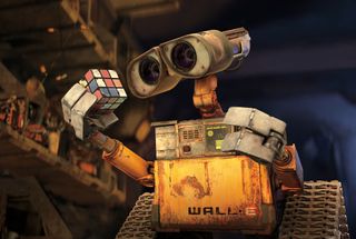 Robot WALL-E examines a Rubik's cube