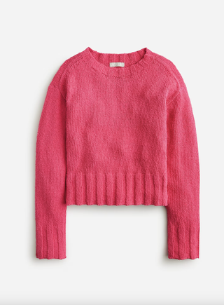 a pink sweater from JCrew in front of a plain backdrop