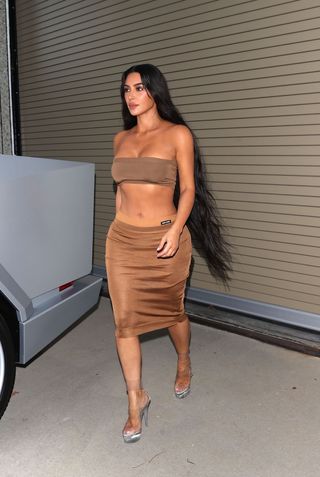 Kim Kardashian wears a MIU MIU designer Skirt and matching Crop top with PVC pleaser heels