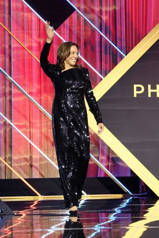 Kamala Harris waving in a black sequin gown