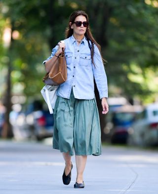 Katie Holmes wearing a denim chambray shirt with a teal skirt and black ballerina slippers in New York City August 2024