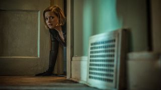 a woman crawls on the ground and looks scared in Don't Breathe