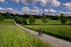 A male cyclist riding on a gravel road in Sweden