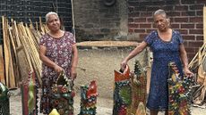 Laura Enriquez Chávez and Asunción Enriquez Chávez standing among their ceramic vessels in their Oaxaca workshop