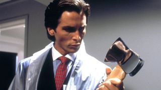 Christian Bale as Patrick Bateman holding an axe during the horror movie American Psycho.