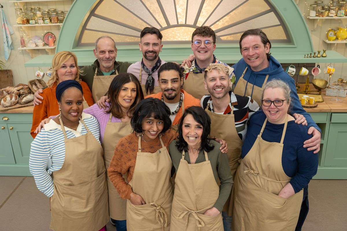 The 12 bakers from collection 12 of “Great British Bake Off” smile and pose.