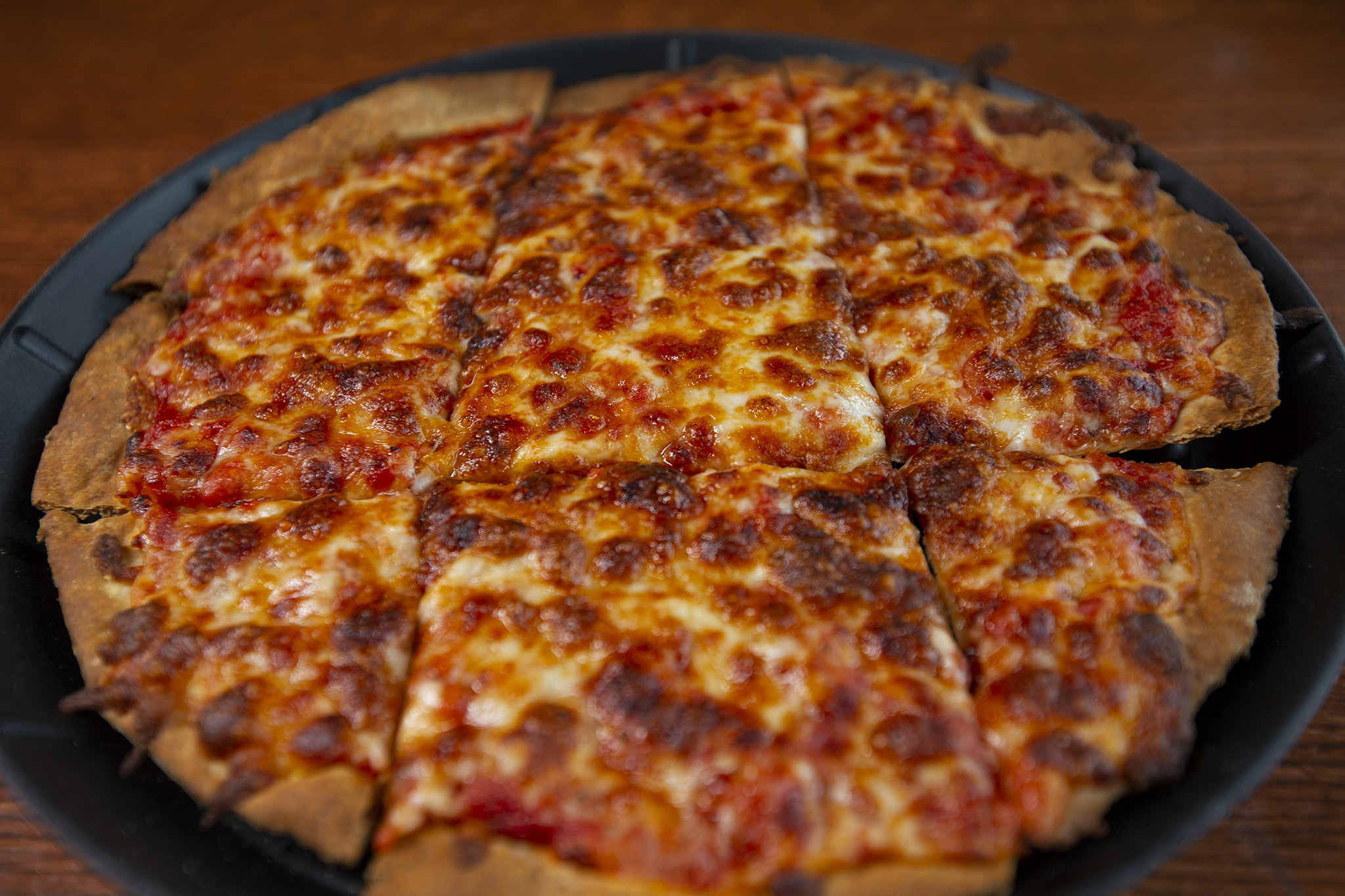 A thin crust Chicago cheese pizza.