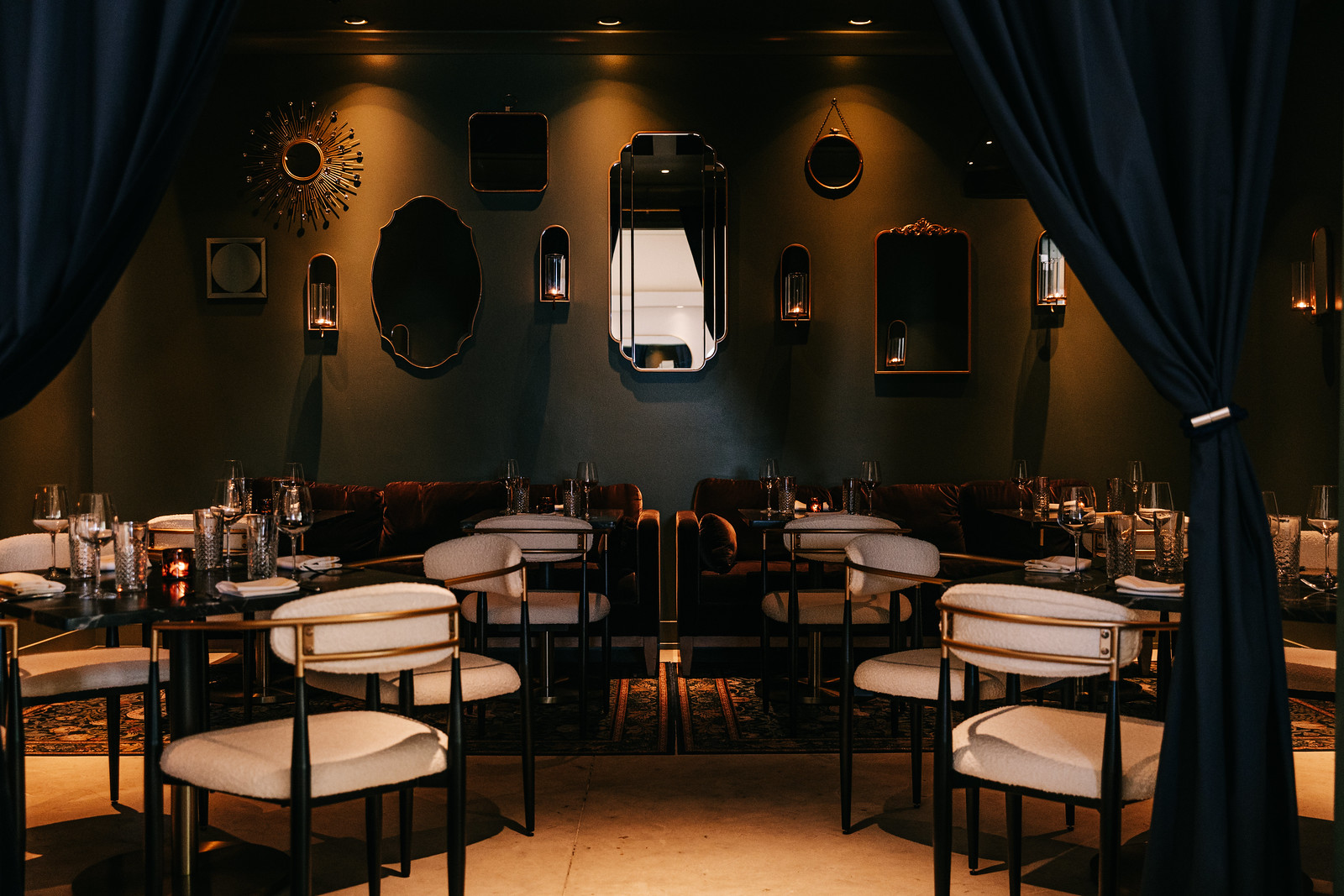 A dimly lit dining room with chairs and tables.