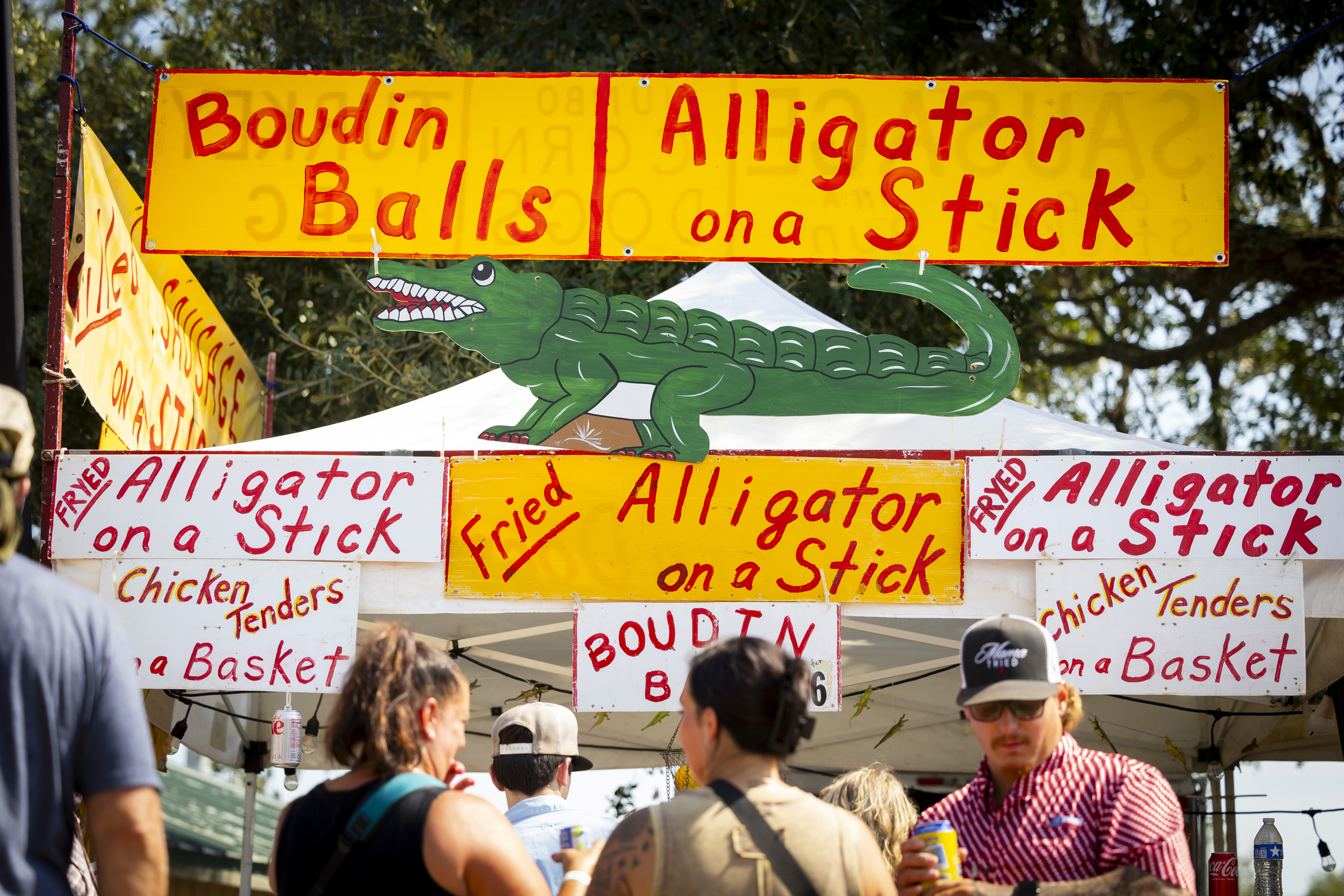 An alligator vendor offers fried alligator on a stick at Texas GATORFEST on Saturday, Sept. 14, 2024, in Anahuac.