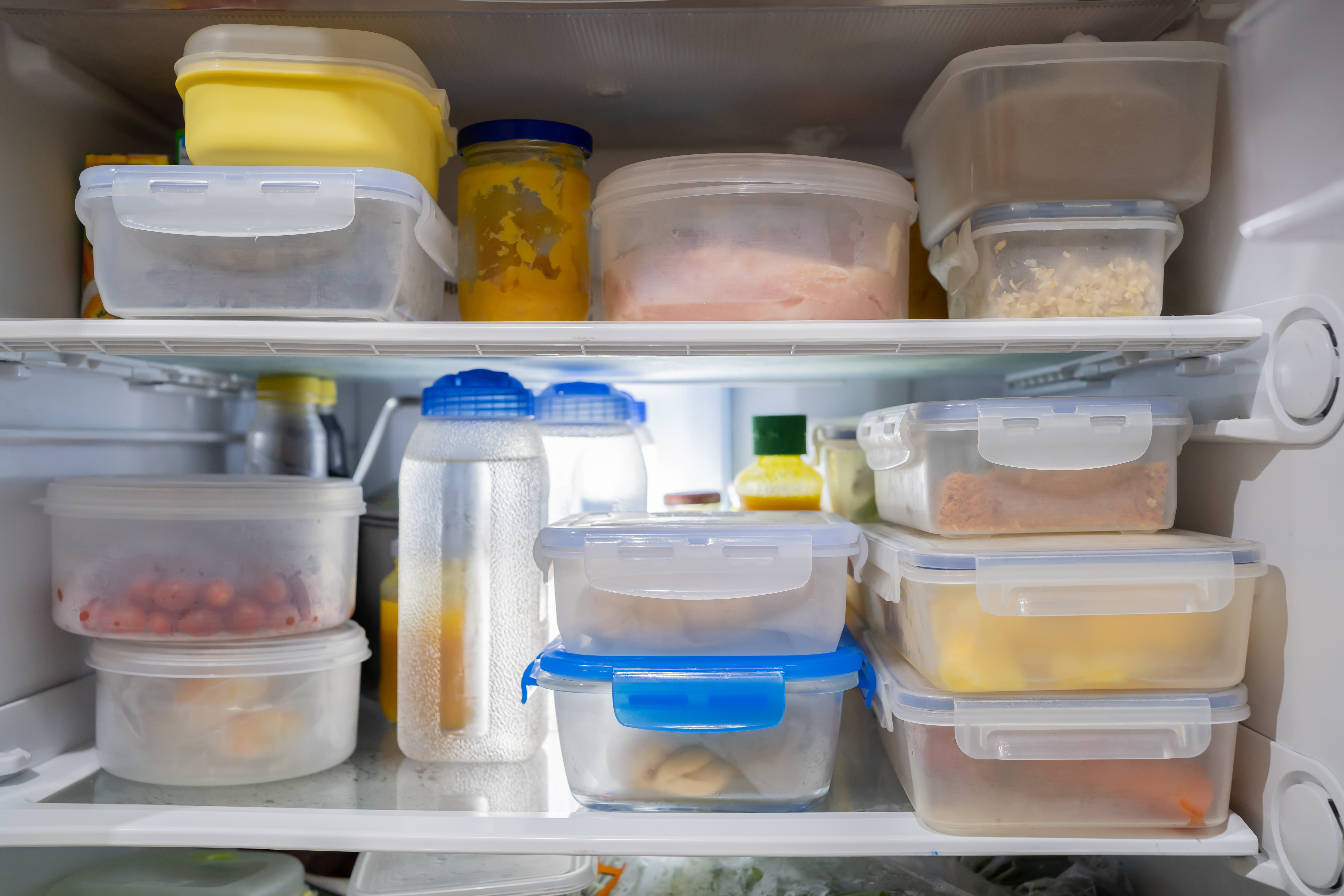 The inside of a refrigerator stacked with different food storage containers.