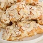 Stack of almond croissants on a white plate.