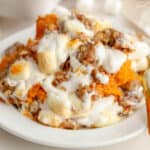 Closeup of sweet potato casserole on a white plate.