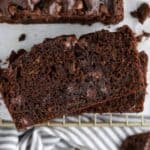 Slices of chocolate zucchini bread on a wire rack.