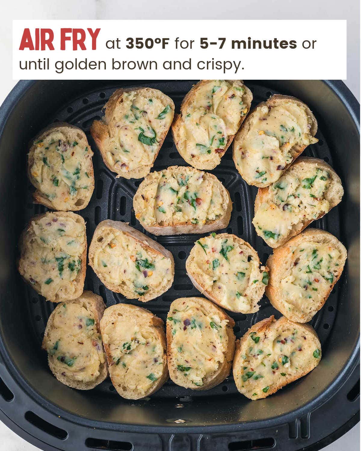 Bread slices in an air fryer basket for Air Fryer Garlic Bread.