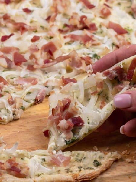 Taking a slice of freshly baked Flammkuchen