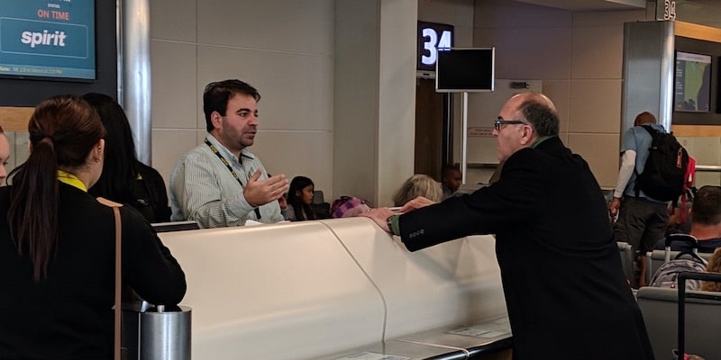Un hombre realiza un reclamo ante un empleado de una aerolínea.