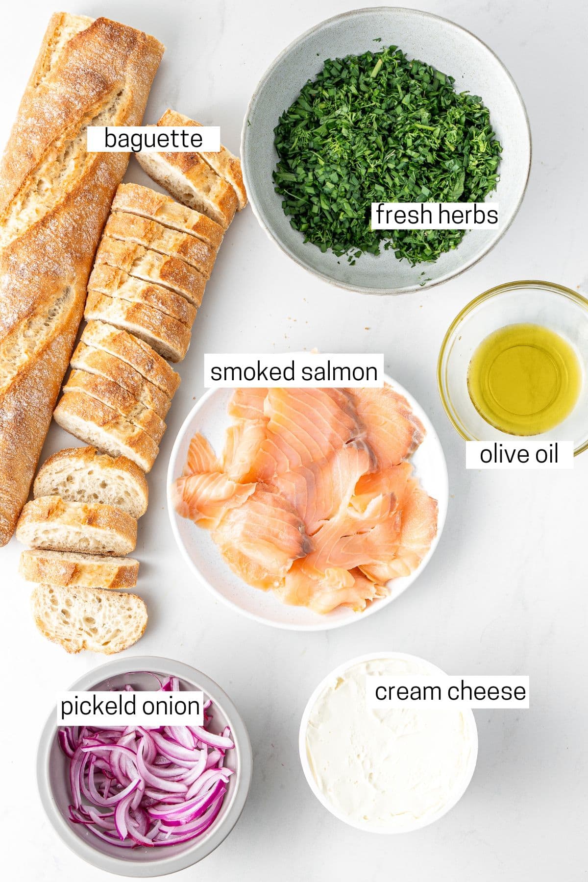 All ingredients needed for smoked salmon crostini laid out in bowls.