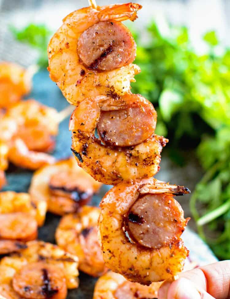 hand holding Sausage and shrimp kabobs