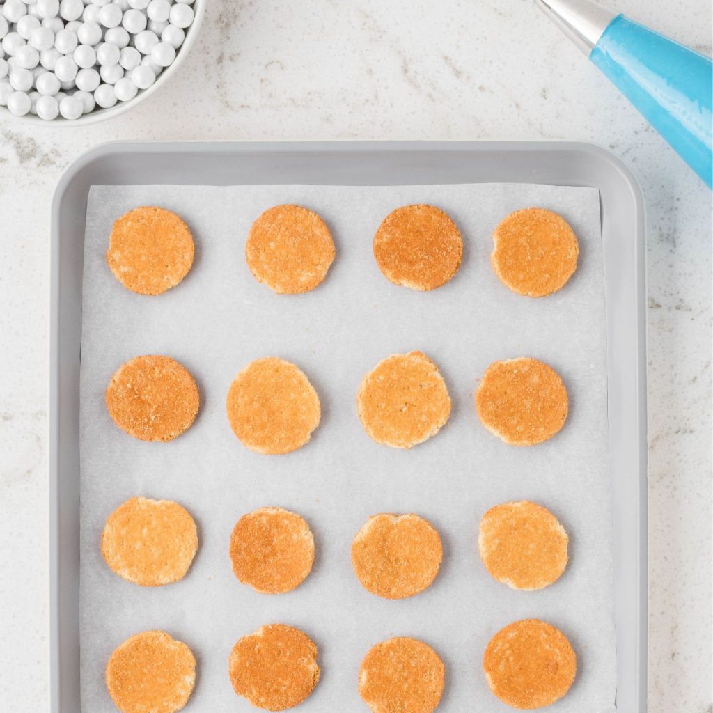 Vanilla wafers on a baking sheet.