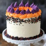 White cake topped with orange and purple frosting.