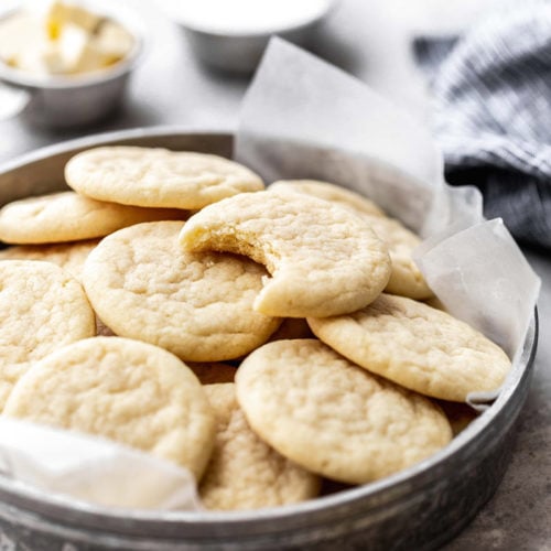 Close up of bitten into Southern Tea Cake on top of several cookies in tin