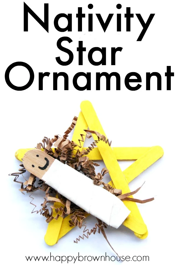 close up of a popsicle stick craft featuring a yellow popsicle stick star, brown shredded paper filler and a large craft stick wrapped in white fabric to represent the Nativity Star and baby Jesus in a manger