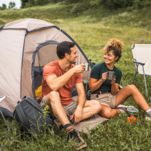 couple in love sit on the grass enjoy camp with coffee and talk