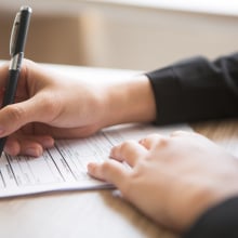 a person writing on a form