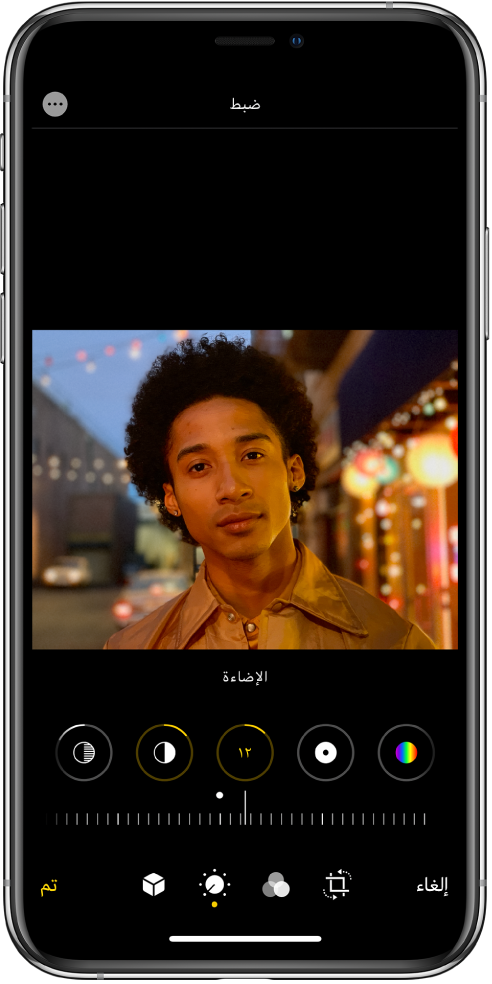 شاشة تحرير مع عرض صورة في المنتصف. أسفل الصورة توجد أزرار تحرير للتمييزات والظلال والإضاءة والنقطة السوداء والتشبع. تم تحديد الإضاءة. أسفل أزرار التحرير، يوجد شريط تمرير لضبط مستويات الإضاءة. أسفل شريط التمرير، من اليمين إلى اليسار تظهر الأزرار إلغاء وبورتريه وتحرير والفلاتر واقتصاص وتم. زر المزيد من الخيارات موجود في الزاوية العلوية اليسرى.
