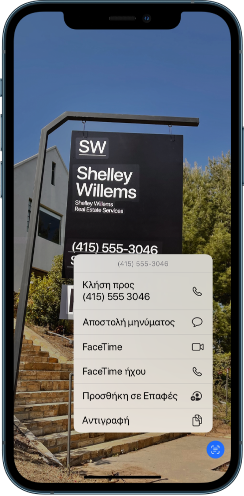 Μια φωτογραφία είναι ανοιχτή σε ολόκληρη την οθόνη. Μέσα στη φωτογραφία υπάρχει μια πινακίδα που περιλαμβάνει κείμενο και έναν αριθμό τηλεφώνου. Ο αριθμός τηλεφώνου είναι επιλεγμένος και οι ακόλουθες επιλογές είναι διαθέσιμες στην οθόνη: Κλήση, Αποστολή μηνύματος, FaceTime, FaceTime ήχου, Προσθήκη στις Επαφές, και Αντιγραφή.