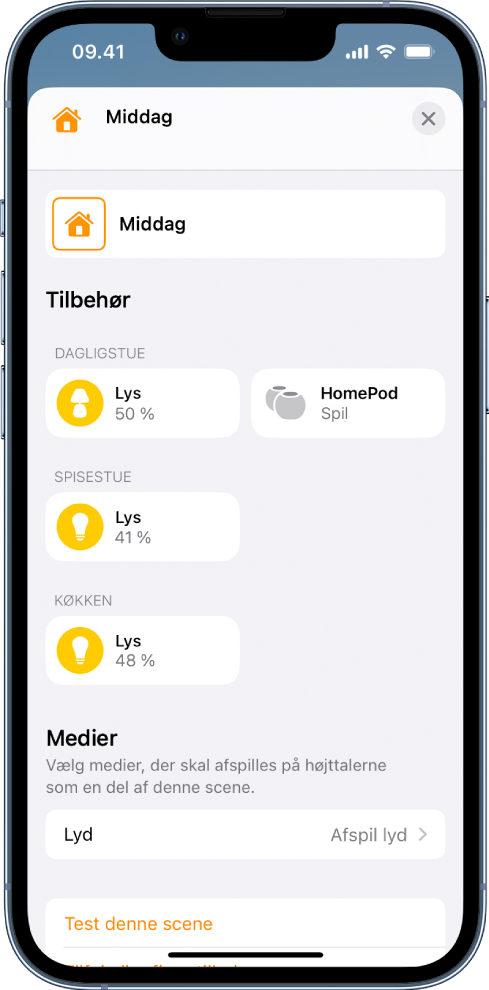 En skærm til sceneredigering i appen Hjem. Navnet på scenen vises øverst på skærmen. Nedenunder er tre værelser og det tilbehør, der er blevet føjet til hvert værelse som en del af scenen. Nederst på skærmen er sektionen Medier, hvor en HomePod i stuen er indstillet til at afspille lyd. Knappen Test denne scene vises nederst på skærmen.