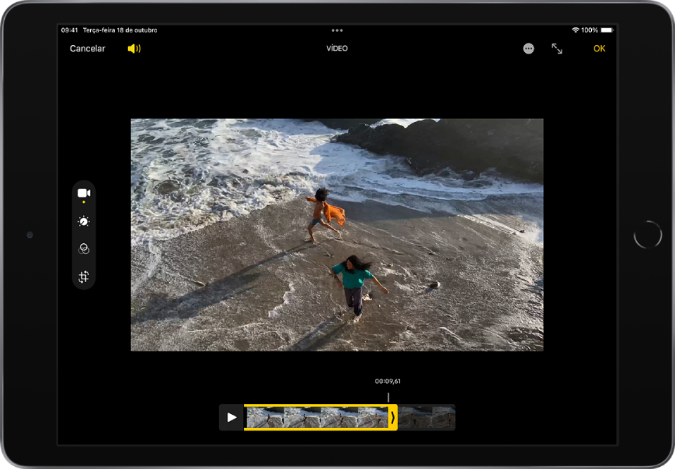 Um vídeo encontra-se na tela Editar e o visualizador de fotogramas está ao longo da parte inferior da tela. Os botões Cancelar e Volume estão no canto superior esquerdo e os botões Entrar em Tela Cheia e OK estão no canto superior direito. As ferramentas de edição estão no lado esquerdo da tela: de cima para baixo, Vídeo, Ajustar, Filtros e Recortar. Vídeo está selecionado.