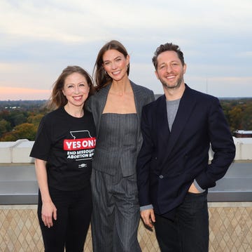 group of three people posing on a rooftop at sunset