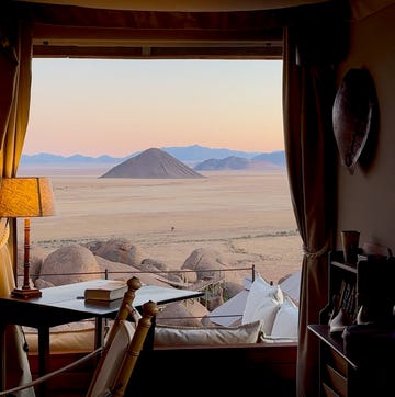 a bedroom with a view of the mountains and the ocean