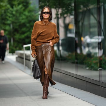 new york, new york september 09 aimee song wears sunglasses, a necklace, a brown wool pullover, a brown leather skirt, a black leather bag, brown knee high boots, outside proenza schouler, during new york fashion week, on september 09, 2023 in new york city photo by edward berthelotgetty images