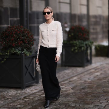 berlin, germany november 30 marlies pia pfeifhofer seen wearing ray ban wayfarer black sunglasses, vintage dior gold statement earrings, hm cream white boucle cardigan jacket, black long maxi skirt, dior white leather mini lady dior bag with embroidered butterflies pattern and ysl black leather cowboy boots, on november 30, 2023 in berlin, germany photo by jeremy moellergetty images