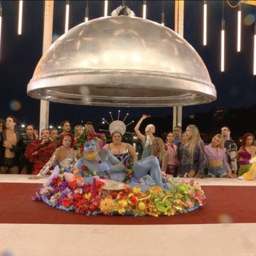 a group of people sitting on a stage with a large circular object in the back